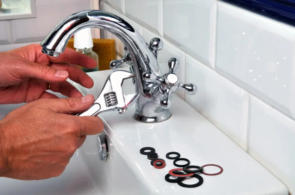 Plumber performing maintenance on a bathroom faucet in Evans