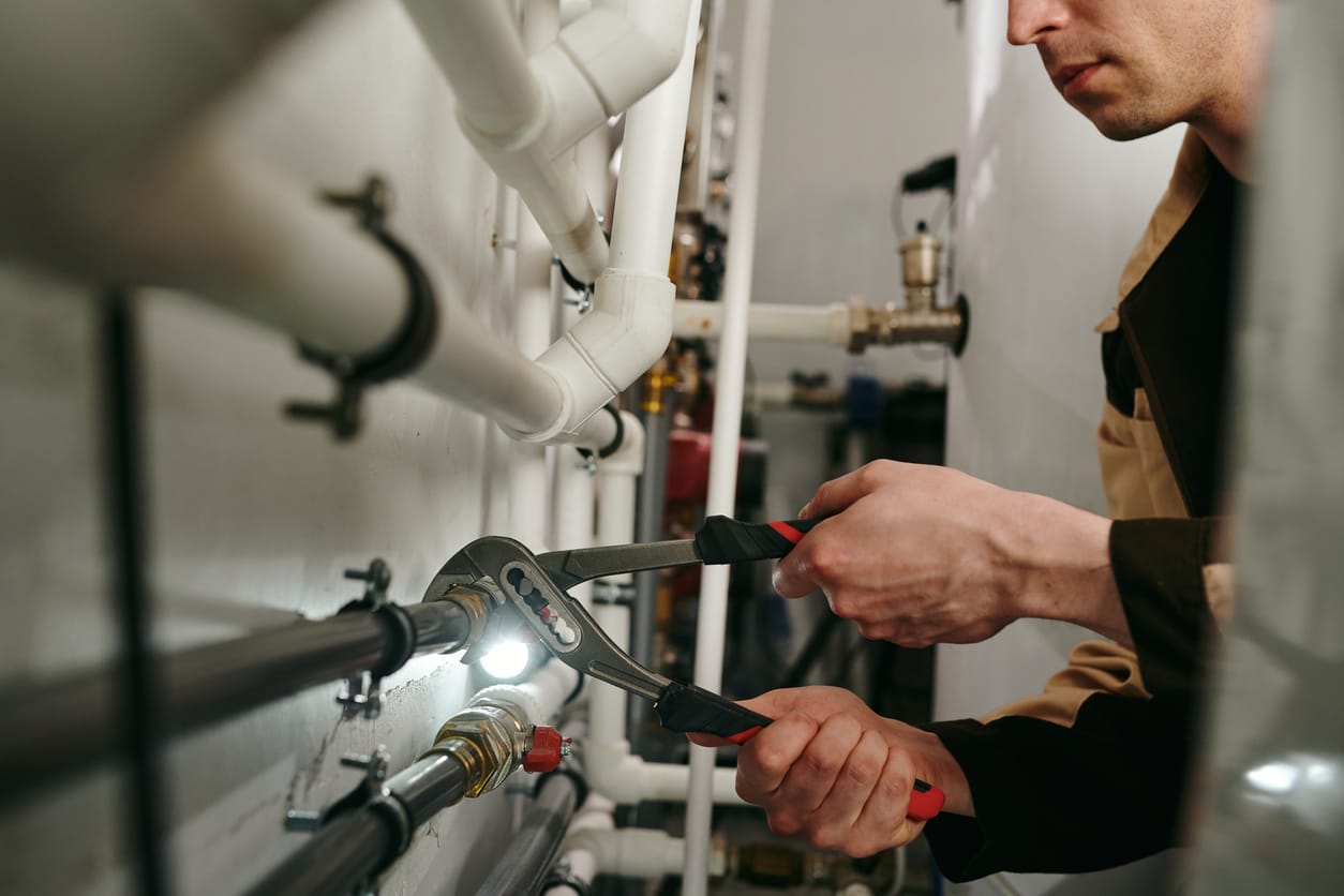 Plumbers maintaining commercial plumbing pipes in Evans