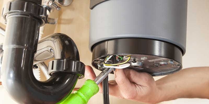 Technician repairing the heating element of a water heater in Evans